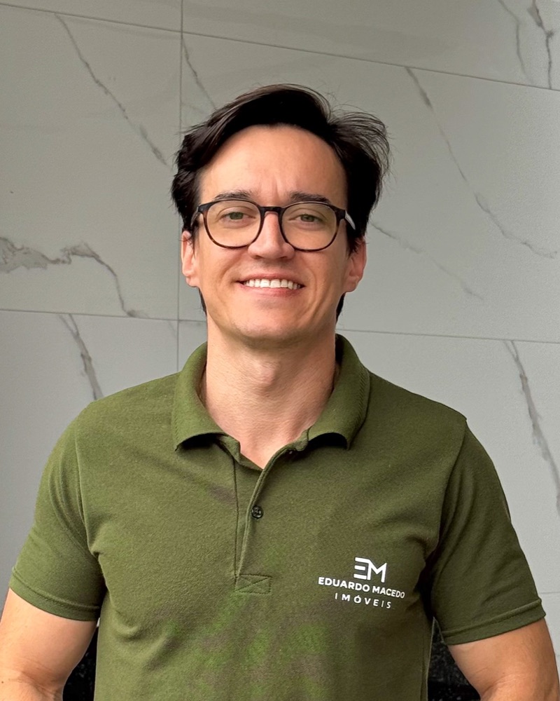 Eduardo Macedo, corretor de imóveis, sorrindo, com a camisa da Eduardo Macedo Imóveis